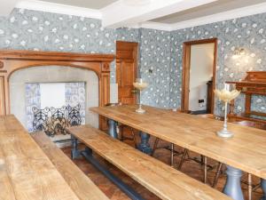 a dining room with wooden tables and a fireplace at Gwern Borter Manor in Conwy