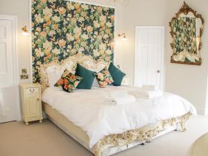 a bedroom with a bed with a floral wallpaper at Gwern Borter Manor in Conwy