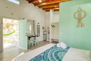 a bedroom with a bed and a door to a patio at DV 4 at DV Cabanas Gold Standard Certified in Caye Caulker