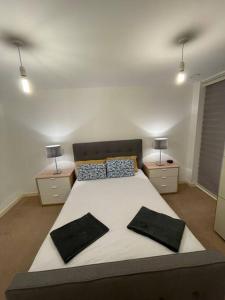 a bedroom with a large bed with two night stands at Spacious 2 Bedroom Modern Flat in London
