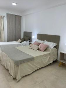 1 dormitorio con 2 camas con almohadas rosas en AIKA Monoambientes en Salta