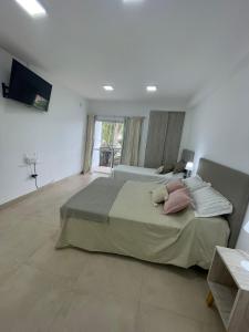 1 dormitorio con 2 camas y TV de pantalla plana en AIKA Monoambientes en Salta