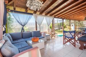 uma sala de estar com um sofá azul e uma mesa em Boem Villa in Nafpliο em Néa Kíos