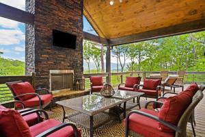 a screened in porch with chairs and a fireplace at Long Ridge Lodge in Cherry Log