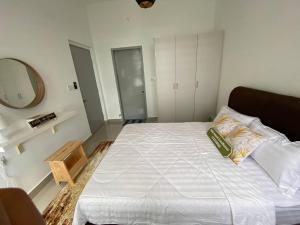 una camera da letto con un grande letto bianco e uno specchio di Fatih Amani Guesthouse with Playstation PS3 a Kajang