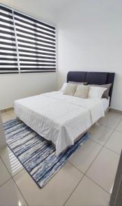 een slaapkamer met een groot bed met witte lakens en een raam bij Fatih Amani Guesthouse with Playstation PS3 in Kajang