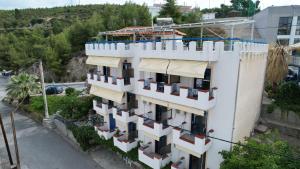 a white building with a white fence on top of it at Egeon Studios in Neos Marmaras