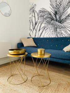 two tables in a living room with a blue couch at Le studio d'Angèle : Angie in Bruz