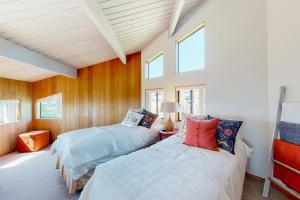 twee bedden in een kamer met houten wanden en ramen bij Just Bluffing in Sea Ranch