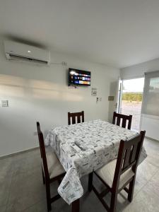uma sala de jantar com uma mesa e cadeiras e uma televisão em Las Soñadas em San Rafael