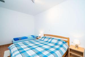 a bedroom with a blue and white bed and a table at Apartment Zuljana 10233a in Žuljana