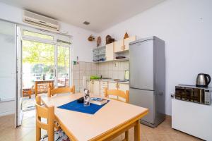 una cucina con tavolo e frigorifero di Apartment Zuljana 10233a a Žuljana