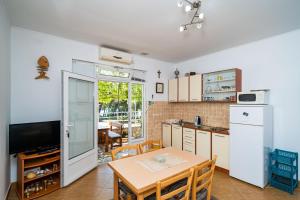 a kitchen with a table and a kitchen with a refrigerator at Apartment Zuljana 10233b in Žuljana