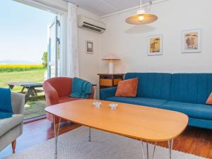 a living room with a blue couch and a table at 6 person holiday home in Lemvig in Lemvig