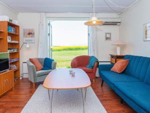 uma sala de estar com um sofá, cadeiras e uma mesa em 6 person holiday home in Lemvig em Lemvig