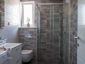 y baño con ducha, aseo y lavamanos. en Lovely Apartment in Imotski with Balcony, en Imotski