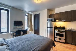 een slaapkamer met een bed en een keuken met een koelkast bij Studio Stays Downtown Montreal in Montreal