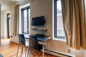 een kamer met een bureau met stoelen en een televisie bij Studio Stays Downtown Montreal in Montreal