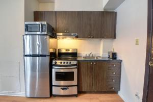 een keuken met een roestvrijstalen koelkast en een spoelbak bij Studio Stays Downtown Montreal in Montreal +5 foto's