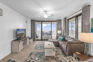 ein Wohnzimmer mit einem Sofa und einem TV in der Unterkunft Pelican Pointe 506 by Vacation Homes Collection in Orange Beach