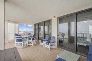eine Terrasse mit blauen Stühlen und einem Tisch auf dem Balkon in der Unterkunft Pelican Pointe 506 by Vacation Homes Collection in Orange Beach