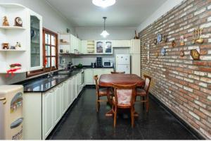 a kitchen with a brick wall and a table and chairs at Casa Salta in Salta