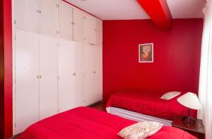 a red bedroom with two beds and white cabinets at Casa Salta in Salta