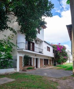 ein weißes Gebäude mit einem Balkon und Bäumen in der Unterkunft Casa Salta in Salta