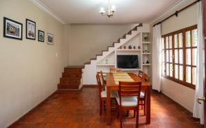 a dining room with a table and chairs and a staircase at Casa Salta in Salta