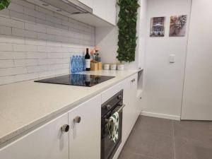 Harrison2BR@Luxury&Stylish Top Floor Apt,Pool,Parking,View的白色的厨房配有柜台和炉灶。
