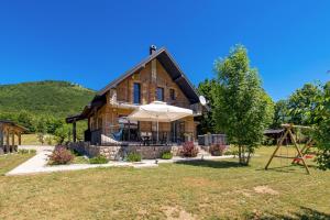 a wooden house with an umbrella and a swing at Family friendly house with a parking space Baske Ostarije, Velebit - 21330 in Brušane
