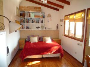 a bedroom with a bed with a red blanket at CasaJardín in Rosario