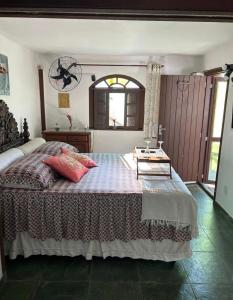 Miramar Chalé e Suítes في انغرا دوس ريس: غرفة نوم مع سرير مع طاولة عليه