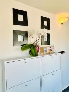 een witte dressoir in een kamer met foto's aan de muur bij Elite Residence in Timişoara