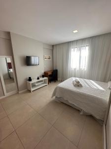 a bedroom with a bed and a desk and a television at Flat localizado a 200m Shopping Recife, bem Perto da Praia de Boa Viagem e com Wi-Fi 400Mbps in Recife