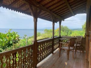 weranda z krzesłami i widokiem na ocean w obiekcie Villa Bakso Mentigi w mieście Teluknarat