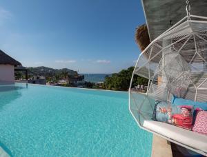 Sayulinda Hotel في سايوليتا: أرجوحة على جانب حمام السباحة