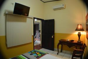 a room with a room with a desk and a television at Hotel Los Balcones de Chinandega in Chinandega