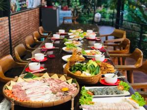 un lungo tavolo con molti piatti di cibo sopra di KOB SUK RESORT k7 , k10 ad Amphoe Sichon
