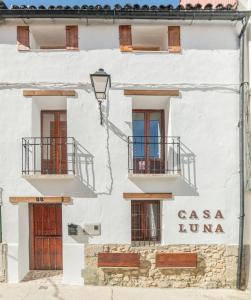 ein weißes Gebäude mit Balkonen und einem Schild darauf in der Unterkunft Casa Luna in Losar de la Vera