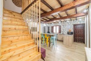a room with a wooden staircase and a table with chairs at Casa Luna in Losar de la Vera