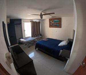 1 dormitorio con 1 cama, 1 silla y 1 ventana en En el centro de Cancun, cerca del ADO, en Cancún