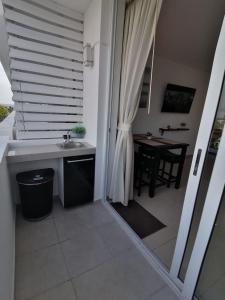 uma casa de banho com um lavatório e uma mesa com uma janela em Playa Blanca SC em Río Hato