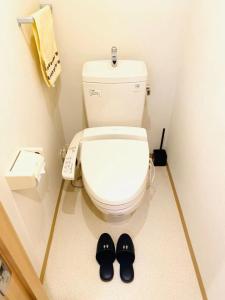 a bathroom with a toilet with a phone and a pair of slippers at Marvelous Kokubunji - Vacation STAY 80468v in Kokubunji