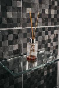 a glass shelf with a jar with sticks in it at El Grano De Oro Hotel in Tupiza