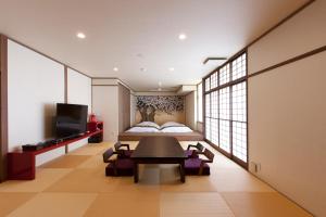 a bedroom with a bed and a table and chairs at Iwaiyado Jyuan Nikko Kawaji onsen in Nikko
