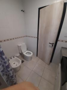 a bathroom with a toilet and a sink and a door at Dpto Piacentini in Resistencia