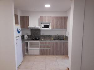 a small kitchen with a sink and a microwave at Dpto Piacentini in Resistencia