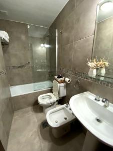 y baño con lavabo, aseo y espejo. en Alberdi - Bon Repos en San Miguel de Tucumán