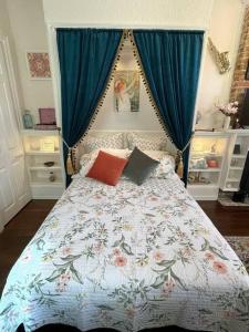 1 dormitorio con 1 cama con cortina azul en Historic Victorian Studio Near City Park NOMA Bayou St John en Nueva Orleans